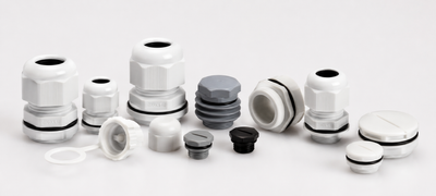 Erinevad plastist läbiviigud, kummiläbiviigud ja otsakorgid elektripaigaldistele heledal neutraalsel taustal.